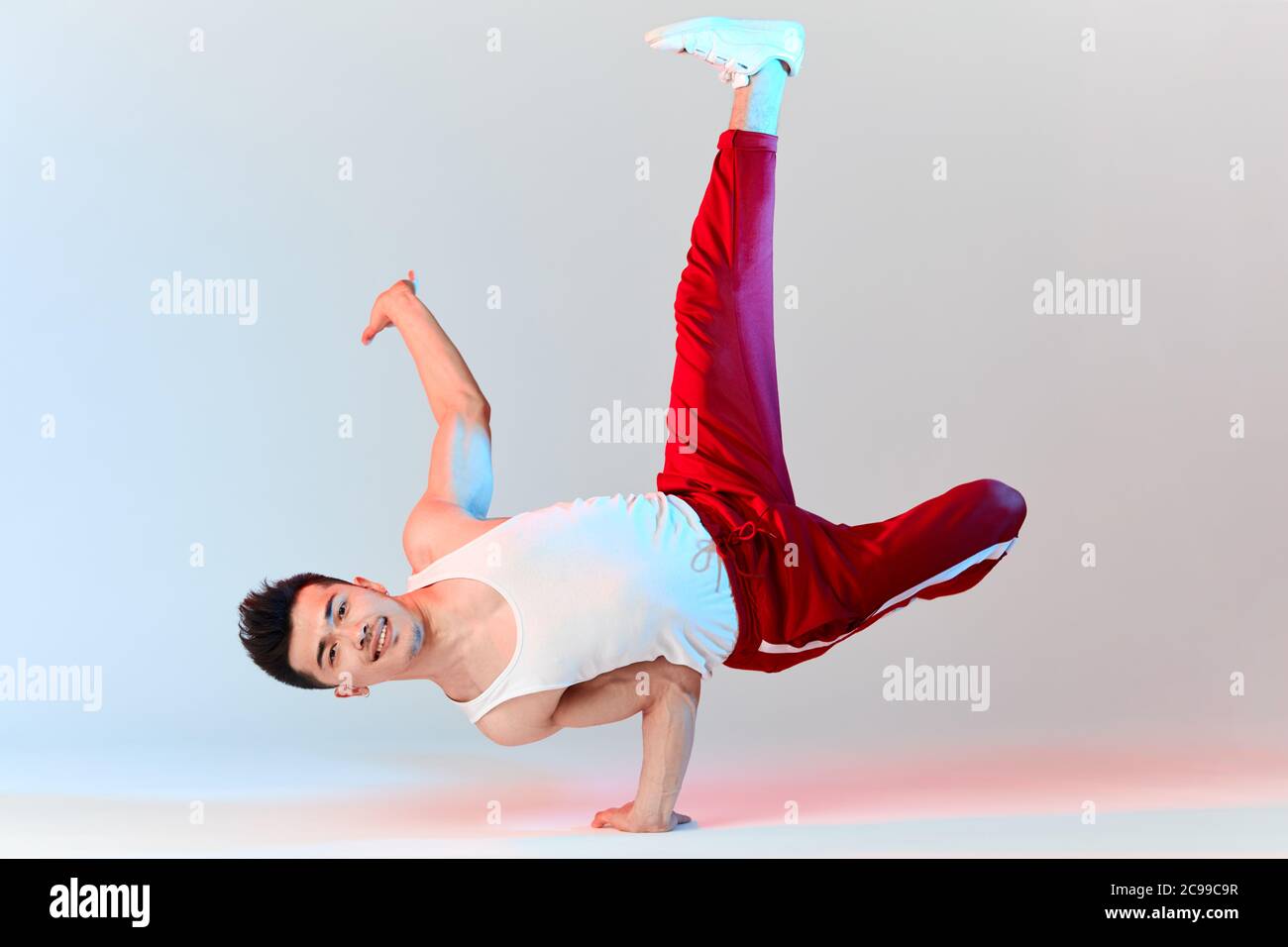 Hip-Hop koreanische Break-Tänzerin in roten Sweathosen bleiben in weißen Klassenzimmer den ganzen Tag und lernen Choreographie von anderen Menschen gemacht, trainieren über Technik Stockfoto