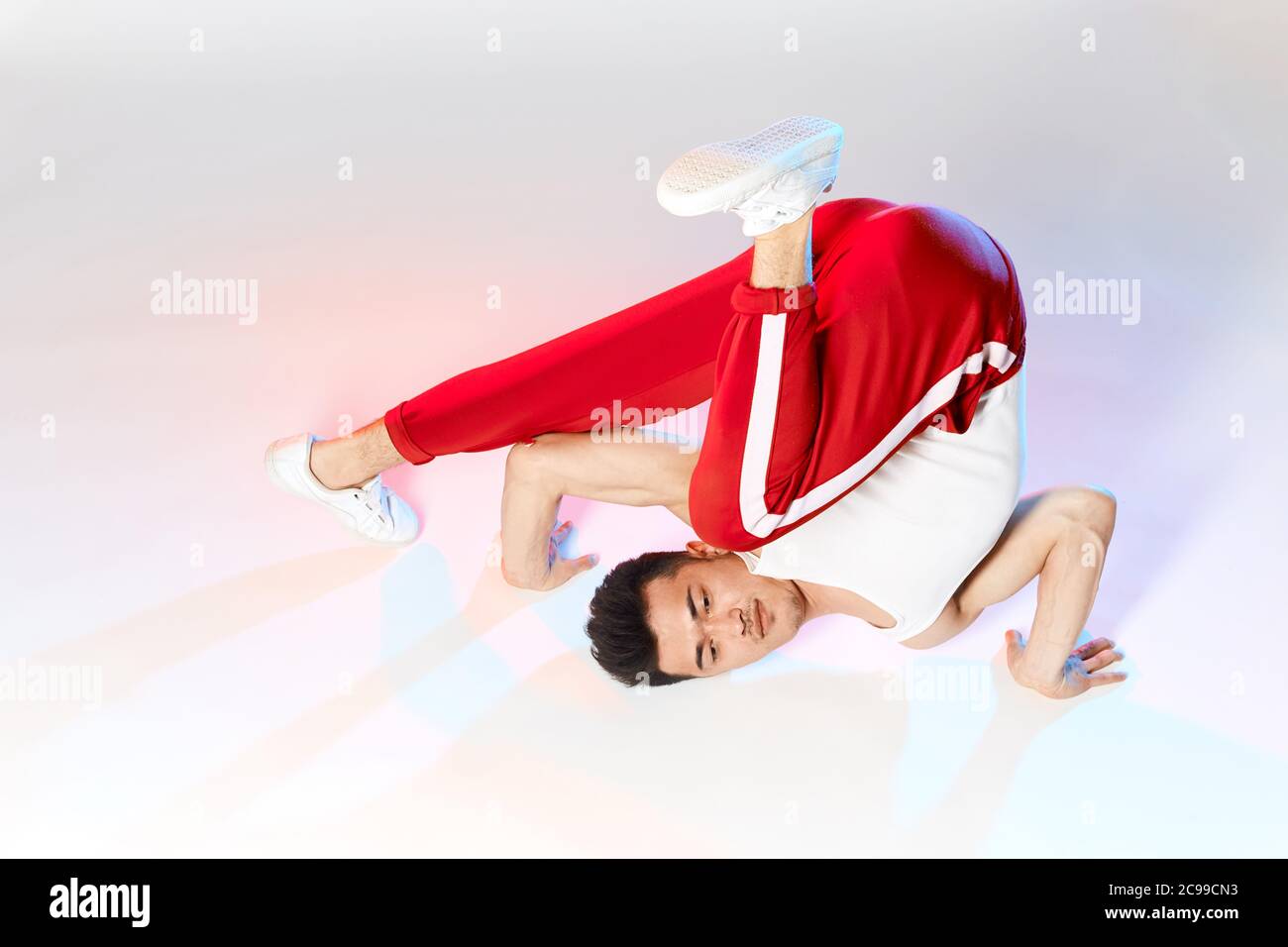 Hip-Hop koreanische Break-Tänzerin in roten Sweathosen bleiben in weißen Klassenzimmer den ganzen Tag und lernen Choreographie von anderen Menschen gemacht, trainieren über Technik Stockfoto