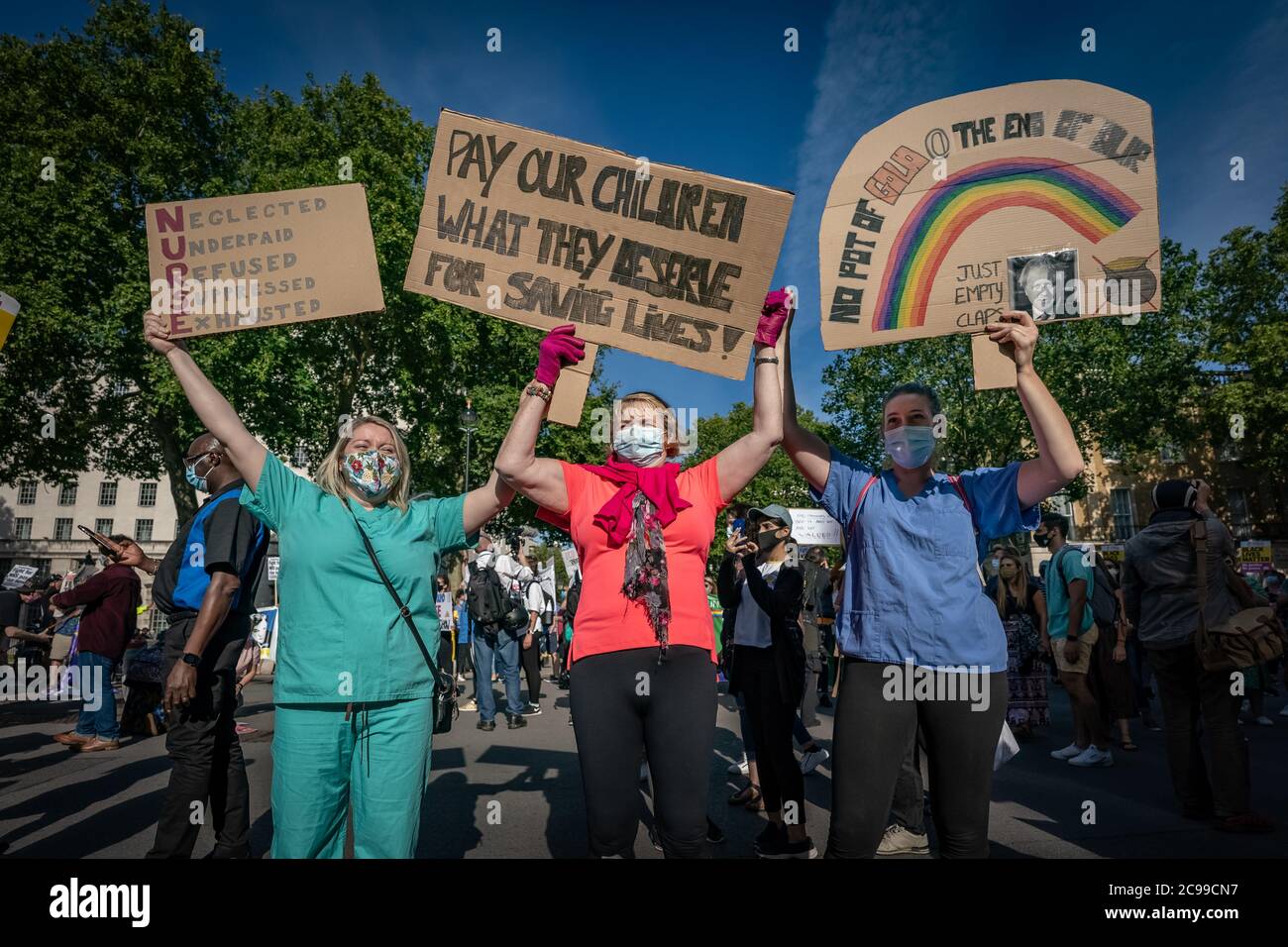 London, Großbritannien. Juli 2020. Coronavirus: NHS Marsch für Pay Justice. Hunderte von NHS-Arbeitern, Schlüsselarbeitern und Unterstützern marschieren vom St. Thomas' Hospital zu den Toren der Downing Street und fordern Lohngerechtigkeit. Die NHS-Arbeiter fordern, dass sie eine Lohnerhöhung für die seit 2010 um 20 % gesenkten Löhne verdienen und sich während der Pandemie COVID-19, die massenhaft Überstunden, Isolation von Familien und den Verlust von über 540 Arbeitnehmern durch das Virus sah, unterbewertet gefühlt haben. Kredit: Guy Corbishley/Alamy Live Nachrichten Stockfoto