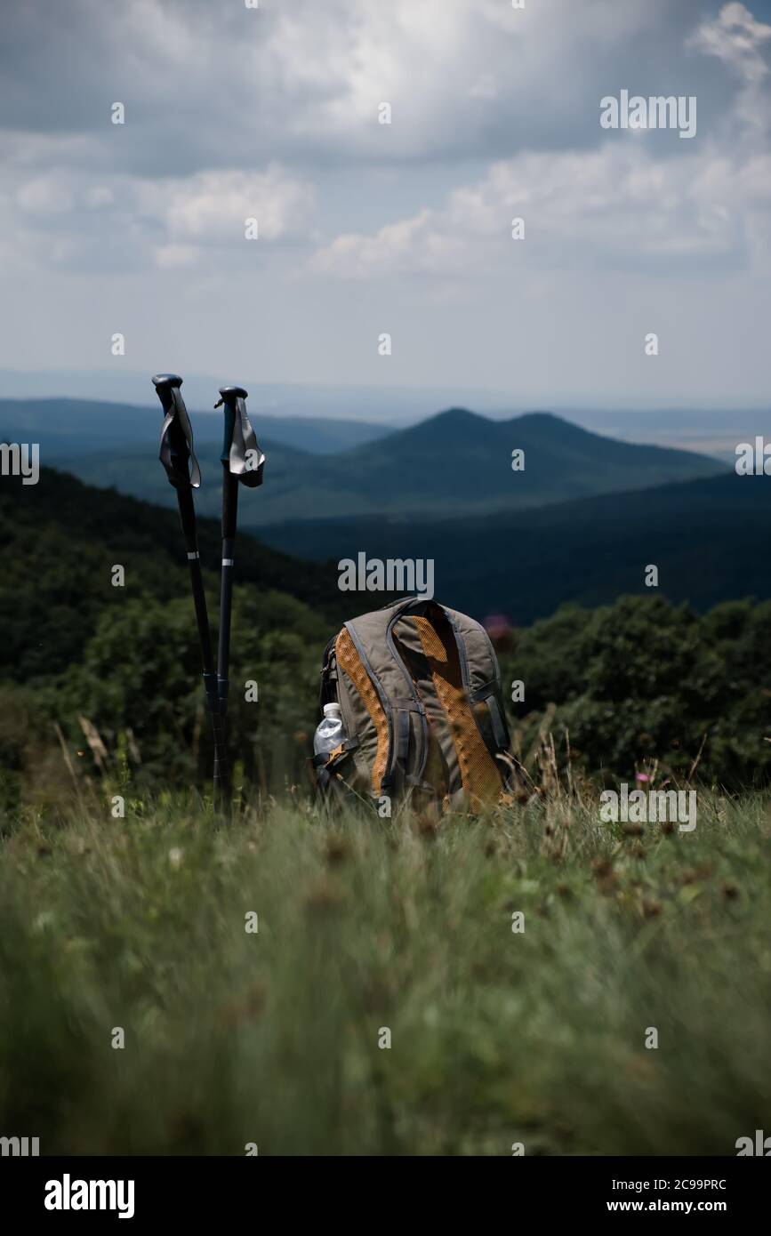 Reise Rucksack und Tour Stöcke auf einem Gras, Morgen Berglandschaft. Stockfoto