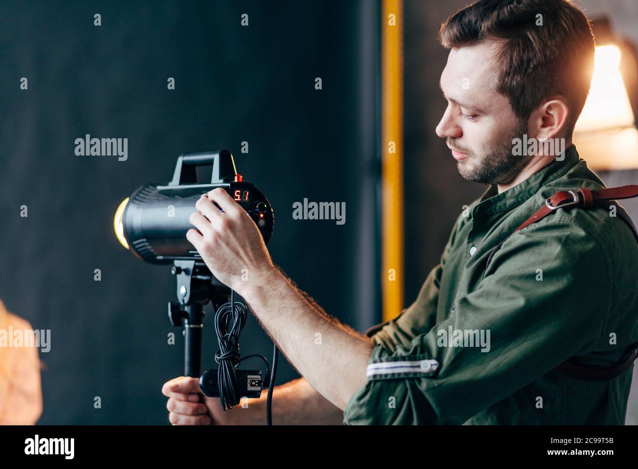 Junge kreative Fotograf Steuerung des Lichts im Studio, close up Seitenansicht Foto. Job, Beruf Stockfoto