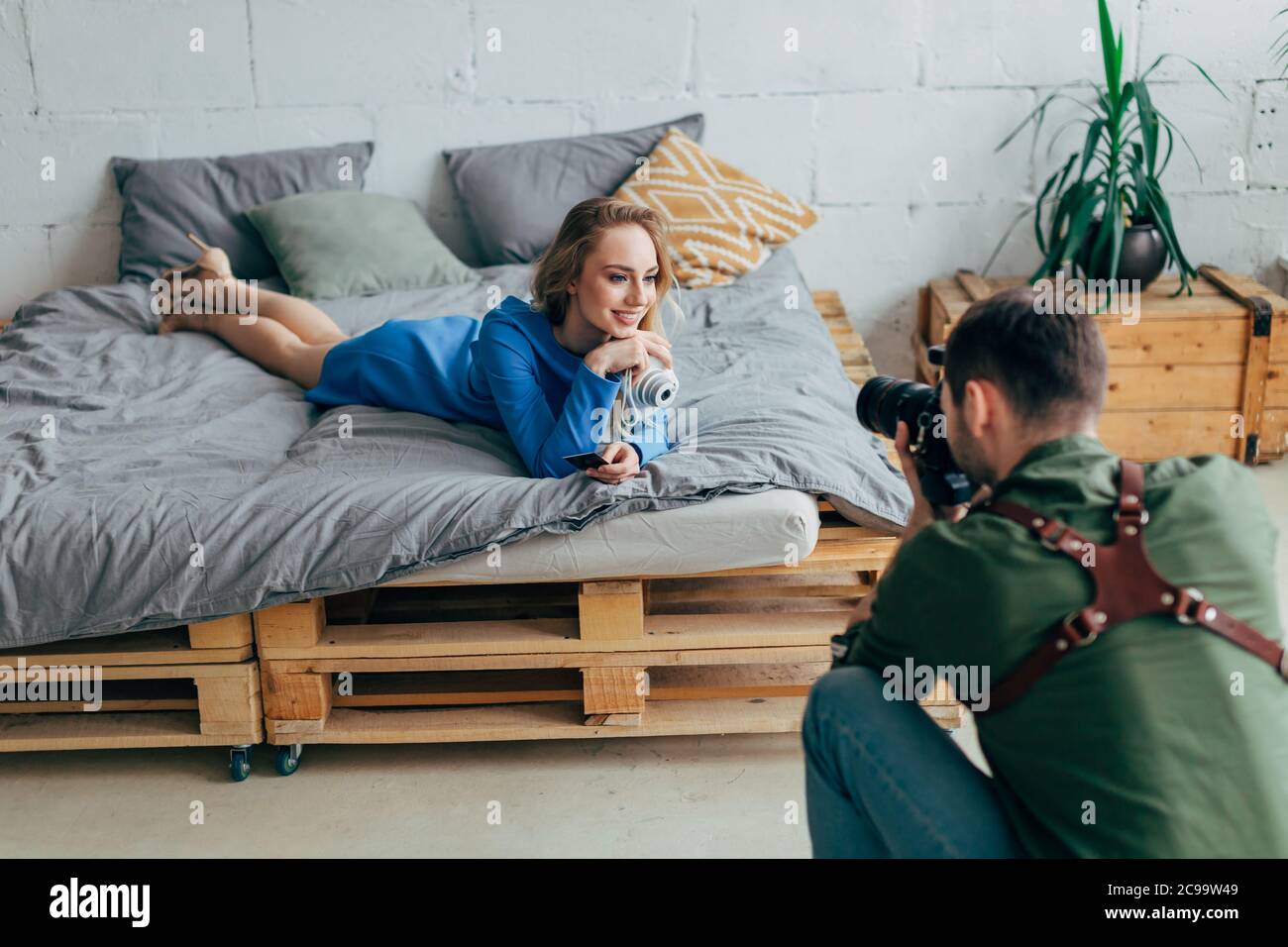 Glückliche Frau hält ein Geschenk von Ehemann und Blick auf die Kamera Stockfoto