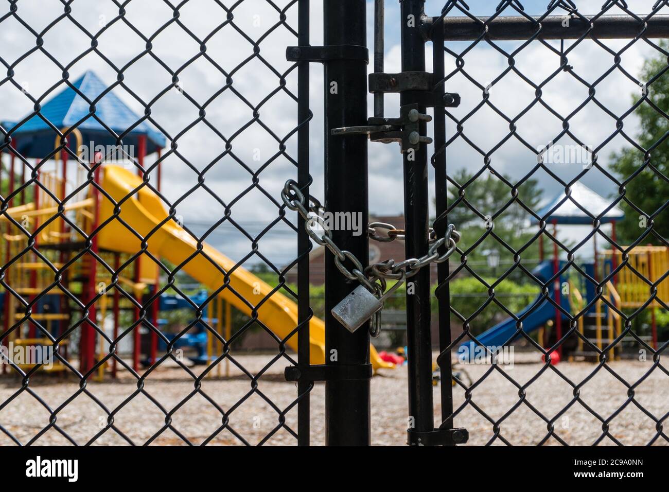 Leerer Spielplatz mit verschlossenem Zaun während der Covid-19-Ära. Stockfoto