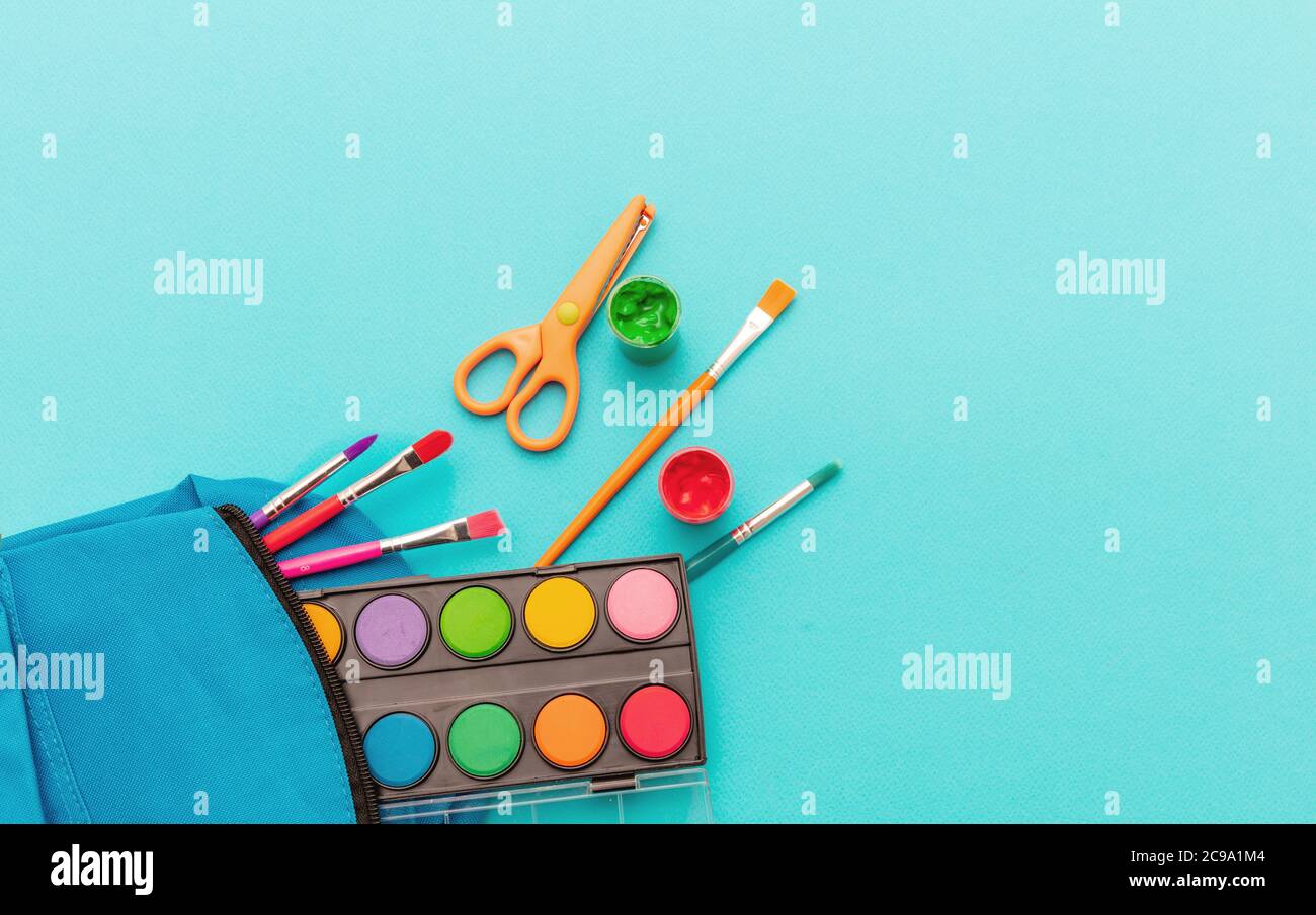 Schulbedarf flach liegend. Schreibwaren auf blauem Hintergrund, Draufsicht, Kopierbereich. Bildung, Back to School, Kinder Kreativität Konzept Stockfoto