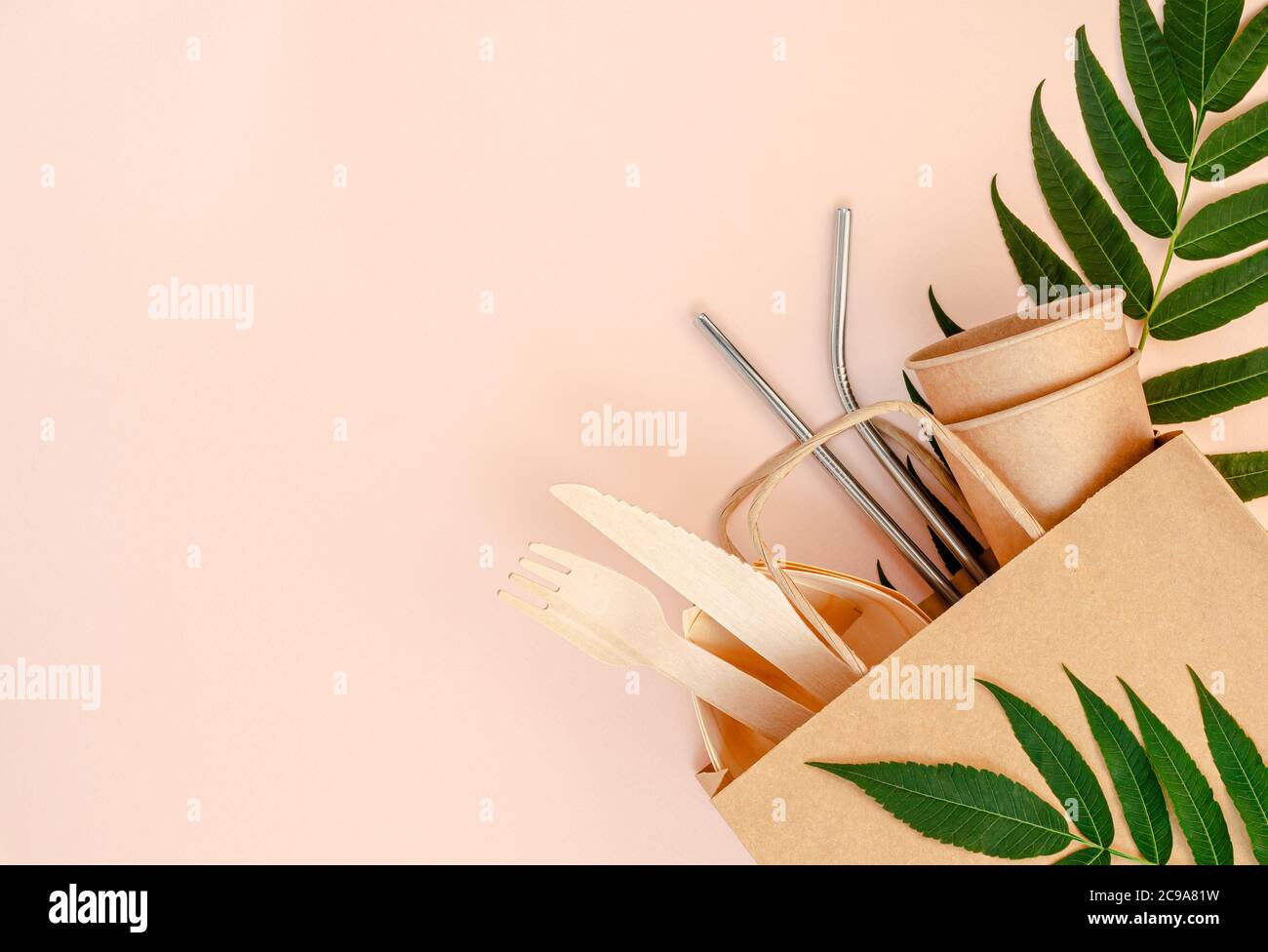 Plastikfreies Set mit Bambus, Papierbesteck und Trinkhalmen aus Metall auf rosa Hintergrund. Zero Waste Konzept. Draufsicht Stockfoto