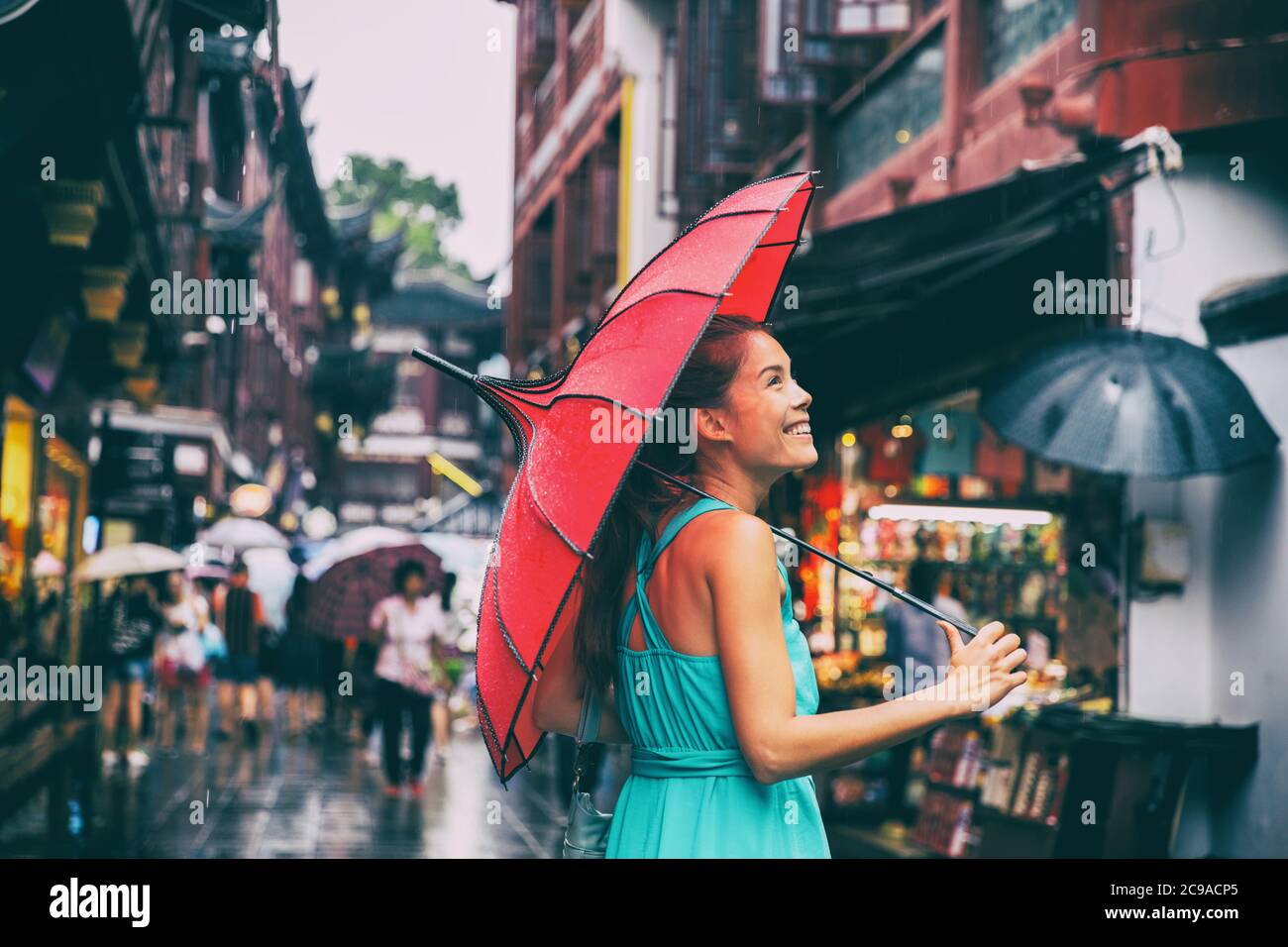 Menschen Lifestyle Regenschirm Reise asiatische Frau einkaufen in chinatown Marktstraße. Regentag Mädchen Tourist unter roten orientalischen Regenschirm in hinteren Gassen in Stockfoto