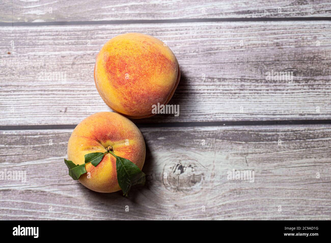 Leckere Pfirsiche Obst aus der Nähe isoliert auf einer Holzoberfläche Stockfoto