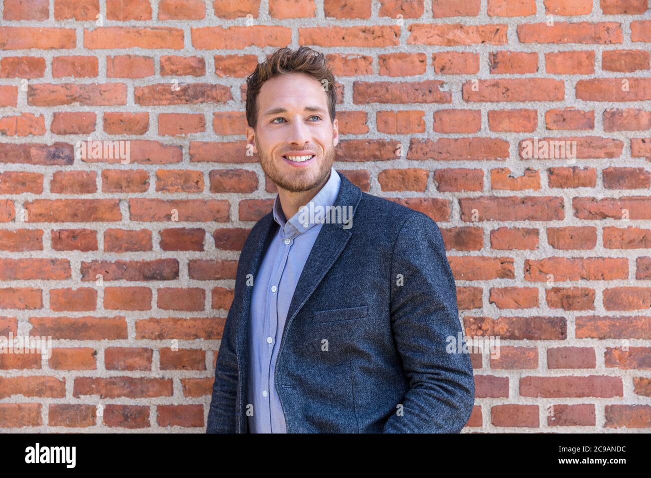 Mann professionelle Geschäftsmann Porträt. Smart Casual Urban Business man lächelt glücklich im Bürogebäude oder Stadtstraße. Schöner Mann in Anzug Stockfoto