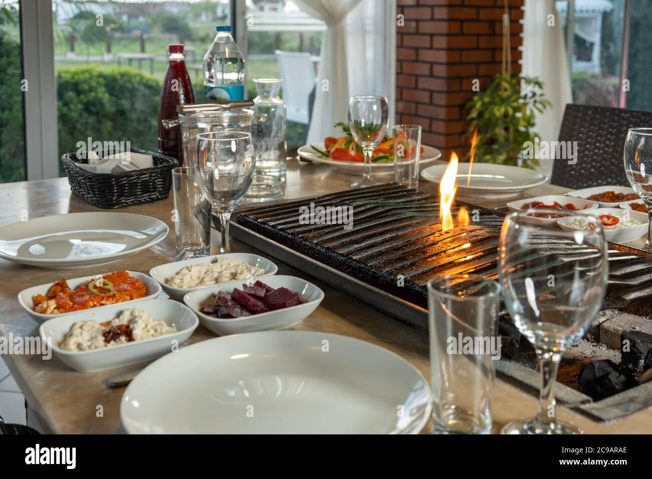 Verschiedene Arten von Fleisch gegrillt auf dem Grill auf dem Tisch, serviert mit speziellen türkischen Vorspeisen und türkischen Raki. Stockfoto