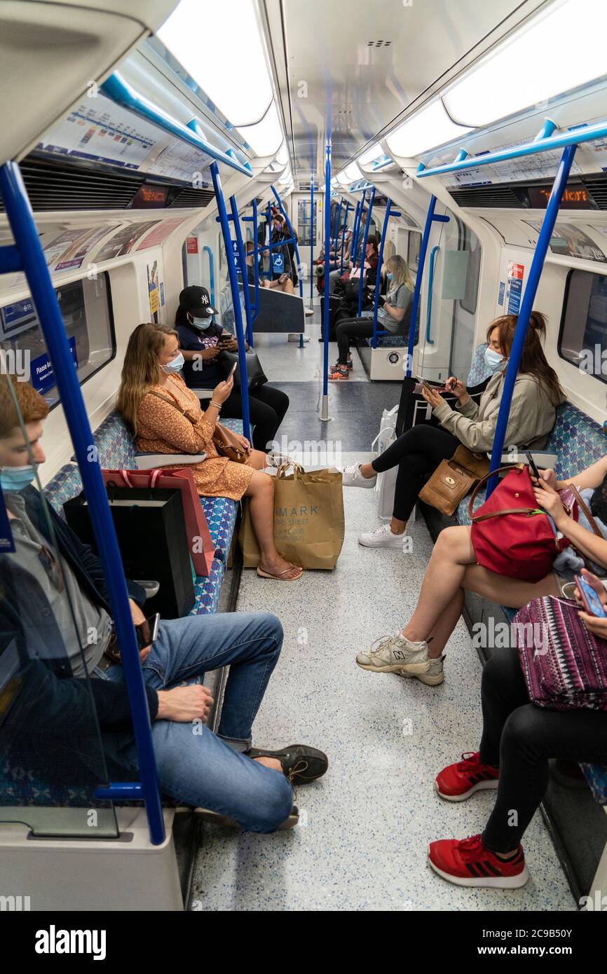 Menschen, die Gesichtsmasken als vorbeugende Maßnahme tragen, werden in der U-Bahn gesehen.die Regierung hat es zur Pflicht gemacht, Gesichtsbezüge an allen öffentlichen Verkehrsmitteln und an verschiedenen Orten wie Geschäften, Banken und Postämtern sowie Geschäften, Supermärkten, Indoor-Einkaufszentren und Bahnhöfen in England zu tragen. Stockfoto