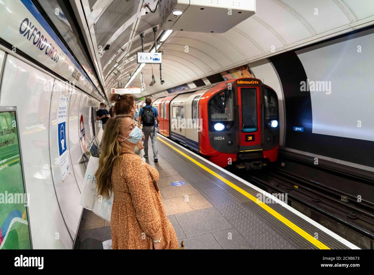 London, Großbritannien. Juli 2020. Die Menschen tragen Gesichtsmasken als vorbeugende Maßnahme an der U-Bahnstation Oxford Circus.die Regierung hat es zur Pflicht gemacht, Gesichtsbezüge an allen öffentlichen Verkehrsmitteln und an verschiedenen Orten wie Geschäften, Banken und Postämtern sowie Geschäften, Supermärkten, Indoor-Einkaufszentren und Bahnhöfen in England zu tragen. Kredit: Edward Crawford/SOPA Images/ZUMA Wire/Alamy Live Nachrichten Stockfoto