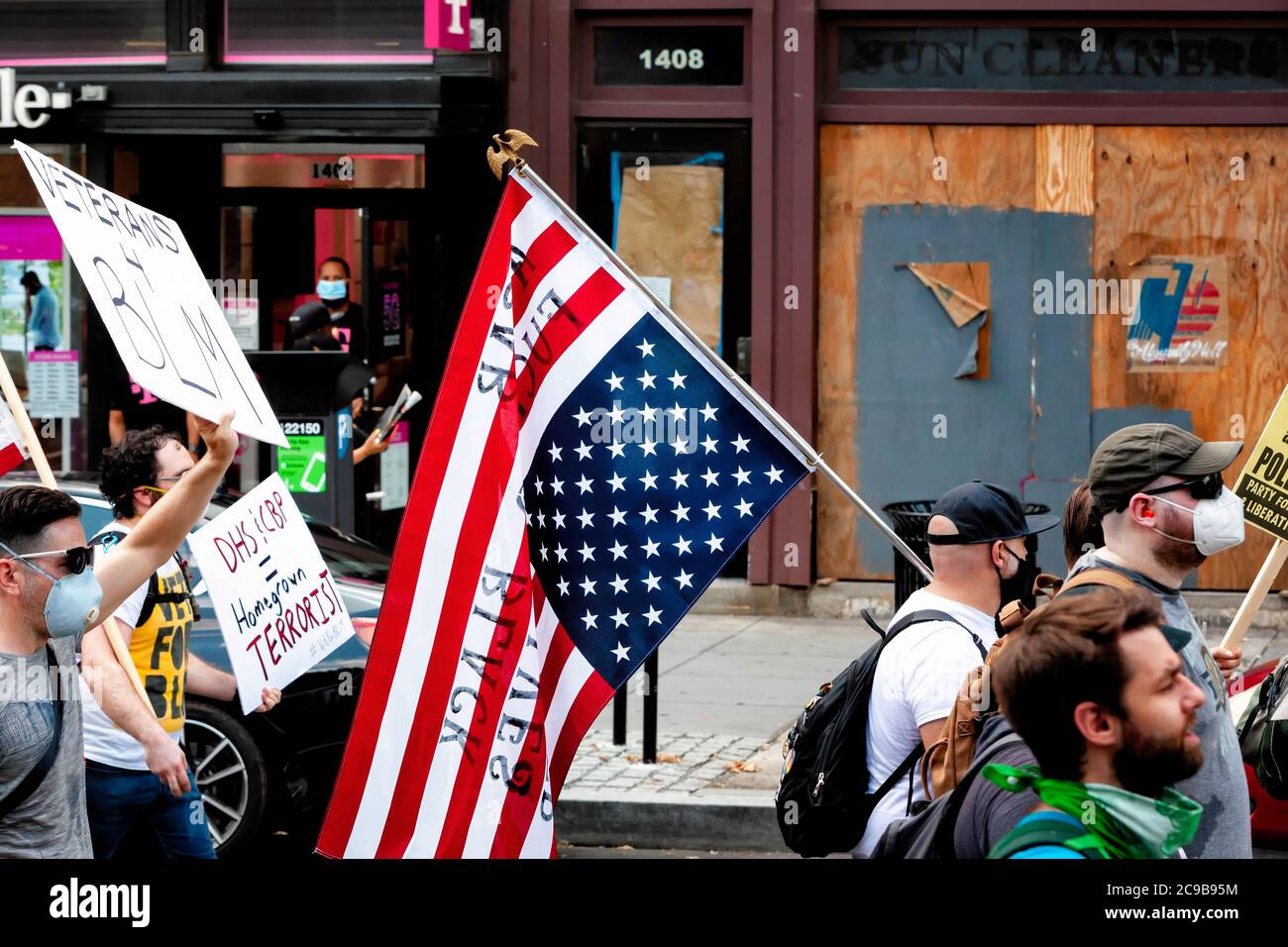 Ein Protestler trägt eine amerikanische Flagge auf dem Kopf beim Marsch gegen Trumps Polizeistaat, Washington, DC, USA Stockfoto