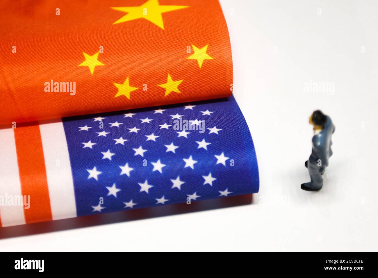 Fuyang, China. Juli 2020. In dieser Abbildung steht eine kleine menschliche Figur neben einer chinesischen Flagge und einer amerikanischen Flagge, die zusammen platziert sind.in den letzten Tagen hat der diplomatische Herabstufung des gegenseitigen Rückzugs der Konsulate zwischen China und den Vereinigten Staaten die Beziehungen zwischen China und den USA angespannt. Kredit: SOPA Images Limited/Alamy Live Nachrichten Stockfoto
