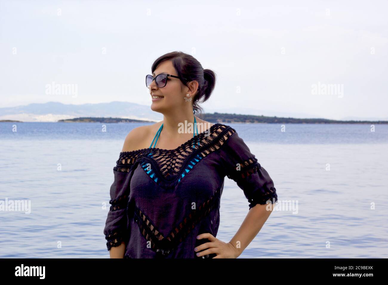 Schöne junge Frau in einer Sonnenbrille am Strand Stockfoto
