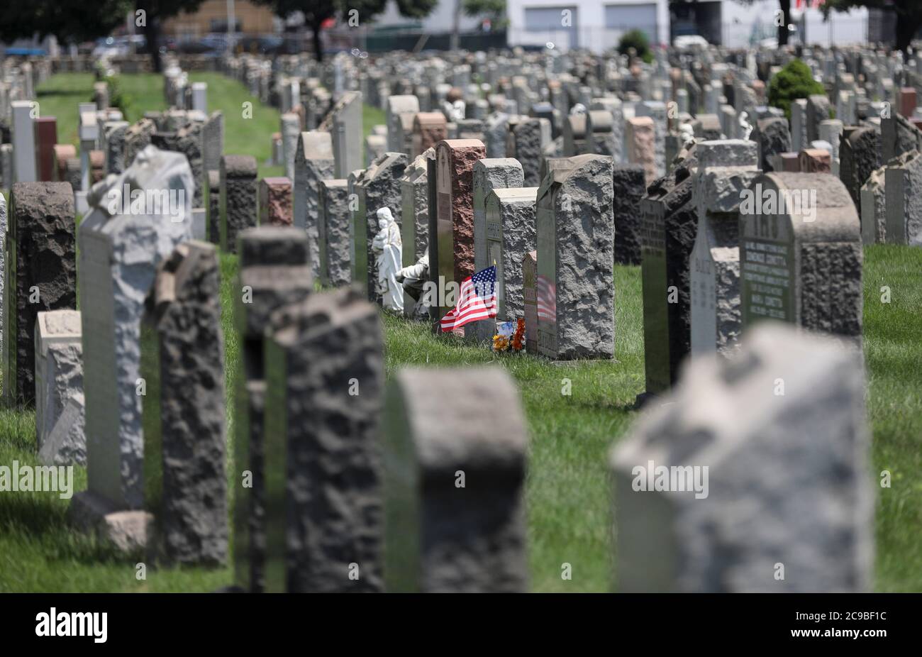 Washington, USA. Juli 2020. Eine US-Nationalflagge und Blumen sind auf einem Friedhof in New York, USA, 29. Juli 2020 zu sehen. Quelle: Wang Ying/Xinhua/Alamy Live News Stockfoto