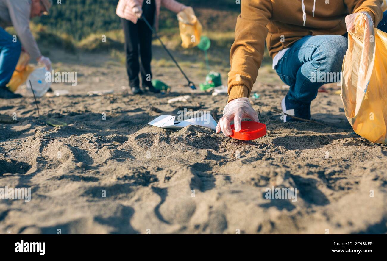 Junger Mann Reinigung der Strand Stockfoto