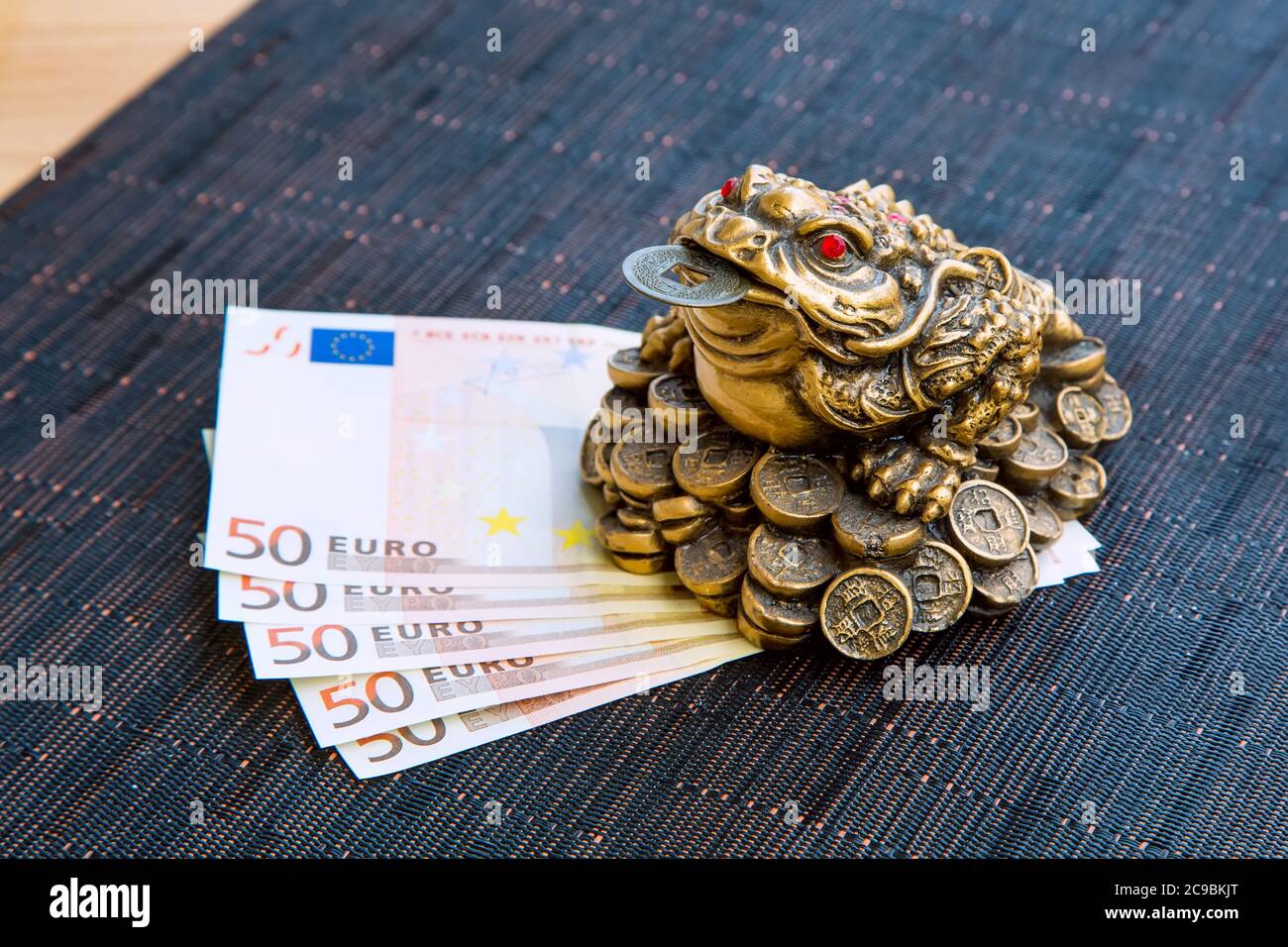Geldfrosch feng Shui Symbol des Wohlstands mit der Münze und Euro-Banknoten  Stillleben Stockfotografie - Alamy