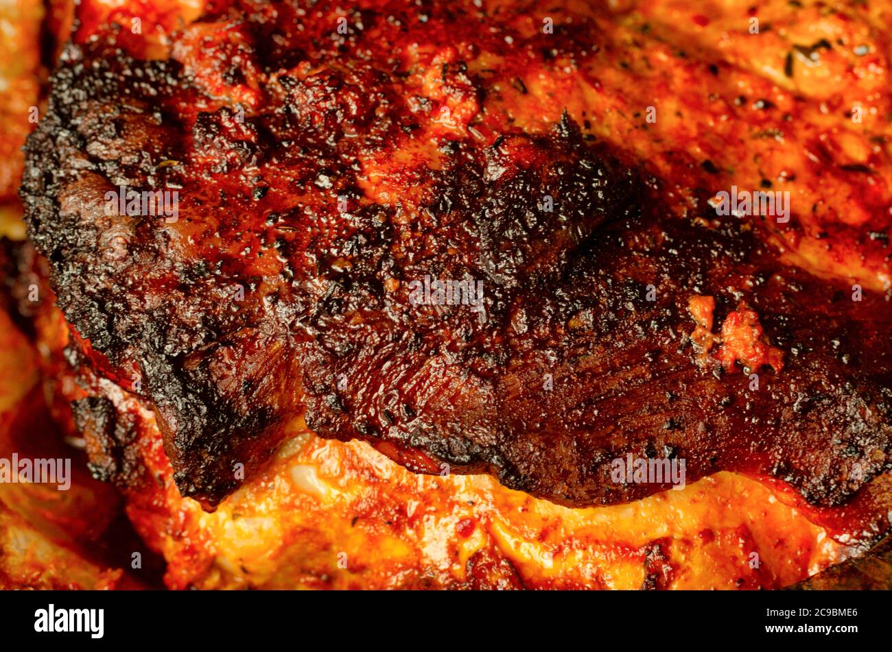 Stark gebräunte Kruste auf einem frisch zubereiteten Stück Schweinefleisch aus nächster Nähe Stockfoto