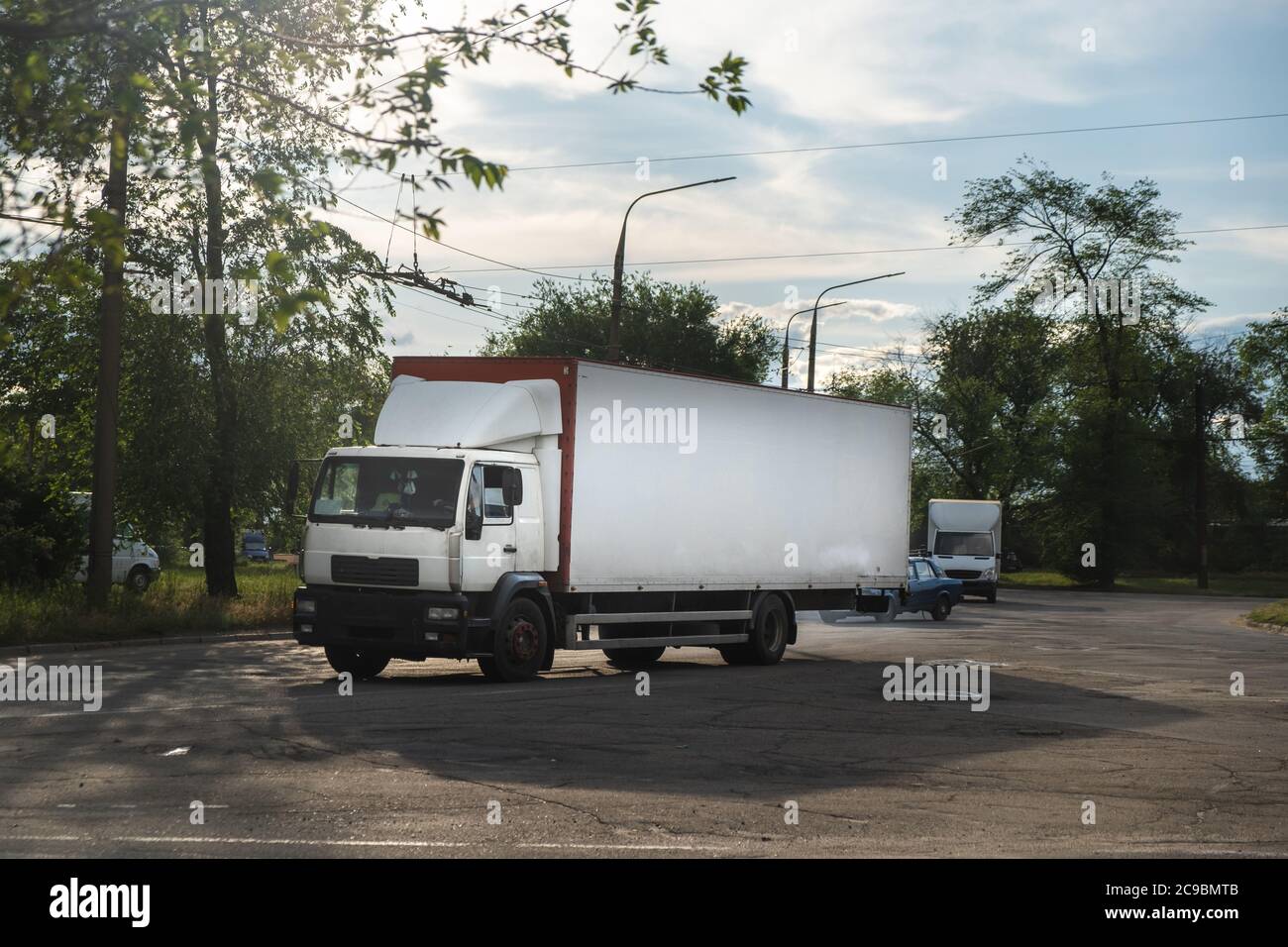 Lieferwagen in der Stadt. LKW auf der Straße. Weißer Lieferwagen auf der Straße. Lieferung Stockfoto