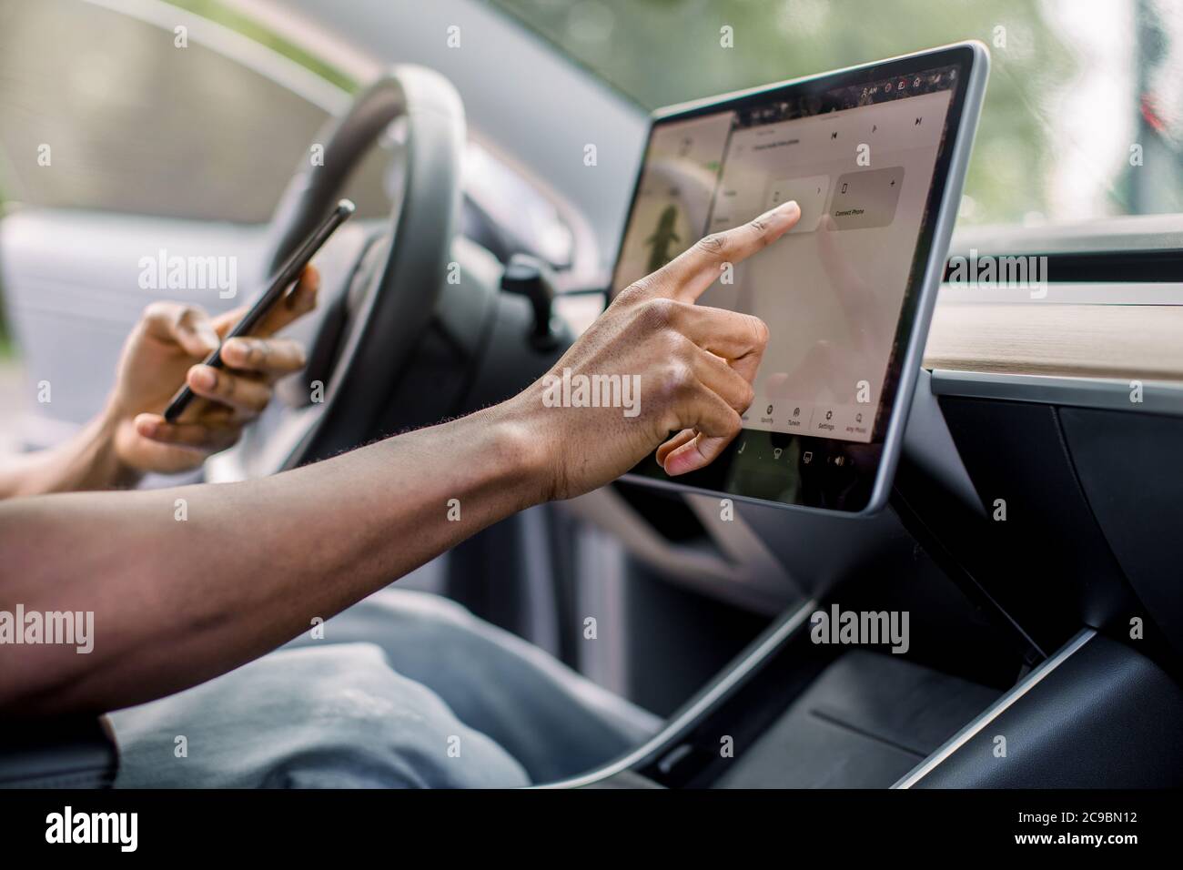 Autopilot selbstfahrende Auto-System ohne menschlichen Eingriff. Nahaufnahme beschnittenes Bild der Hand von afrikanischen männlichen Fahrer Surfen im Internet mit Stockfoto