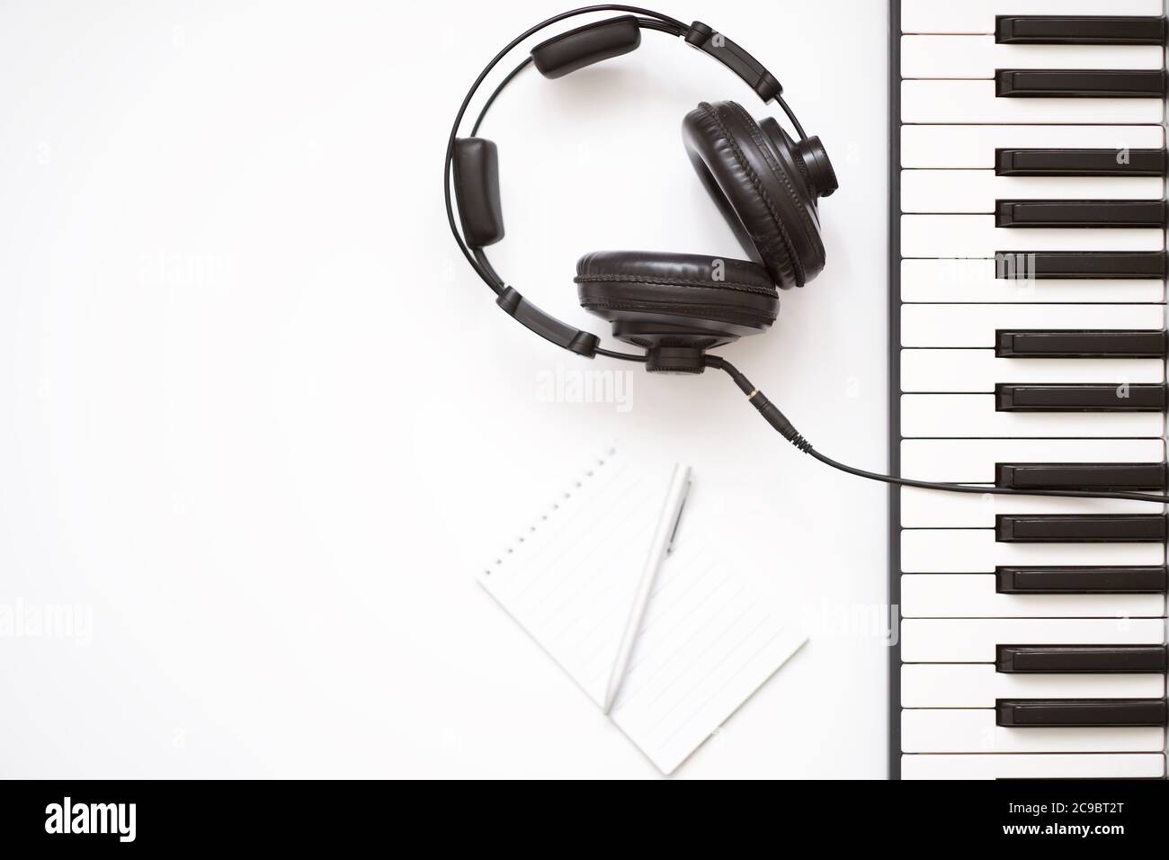 Musikvorlage mit Keyboard-Synthesizer mit Kopfhörer auf weißem Hintergrund. Stockfoto
