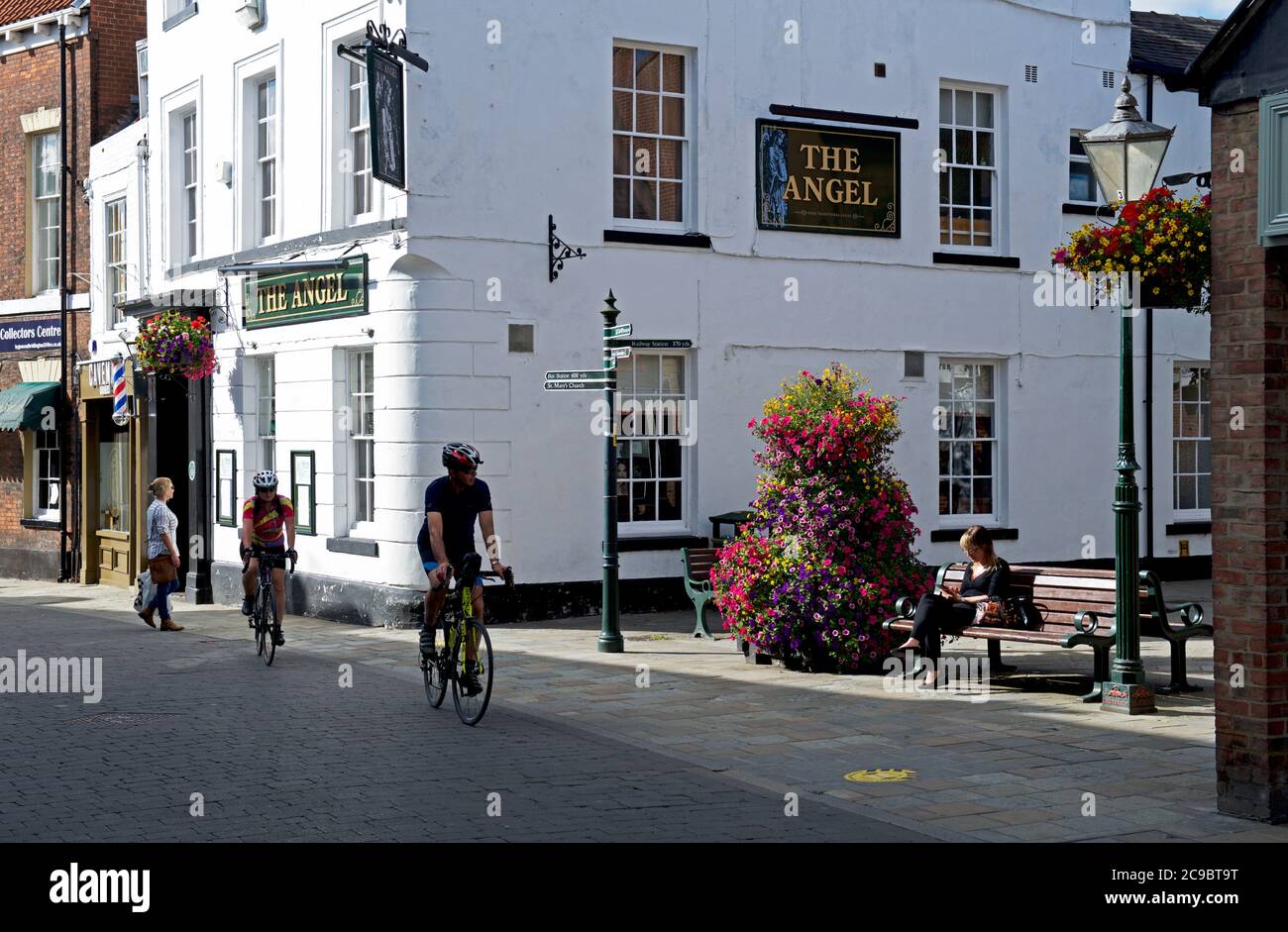 Fahrradfahrer, die am Angel Pub, Butcher Row, Beverley, East Yorkshire, England vorbeifahren Stockfoto