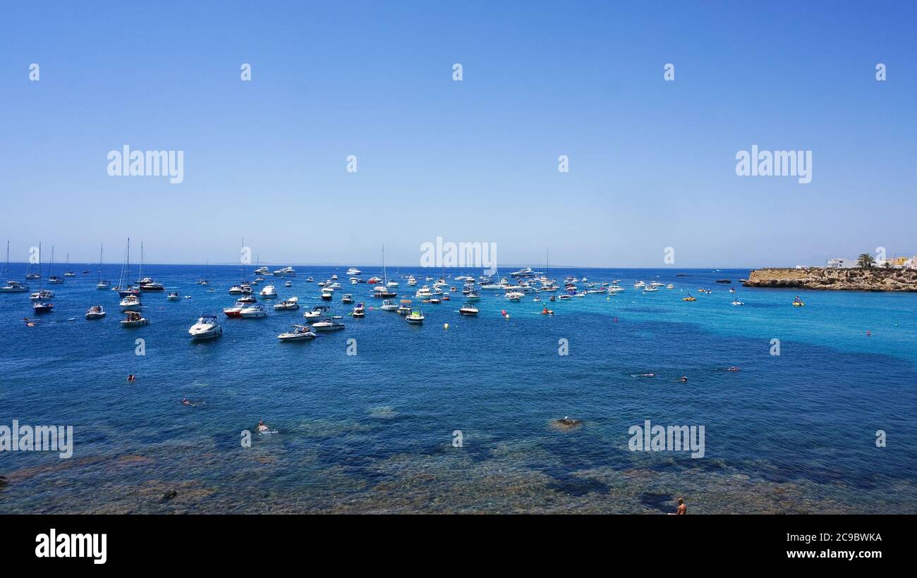 Tabarca, Alicante, Spanien Juli, 2020: Blick auf das blaue Meer der Insel Tabarca, Segelboote und Katamarane mit entspannenden Menschen an heißen sonnigen Tagen Stockfoto