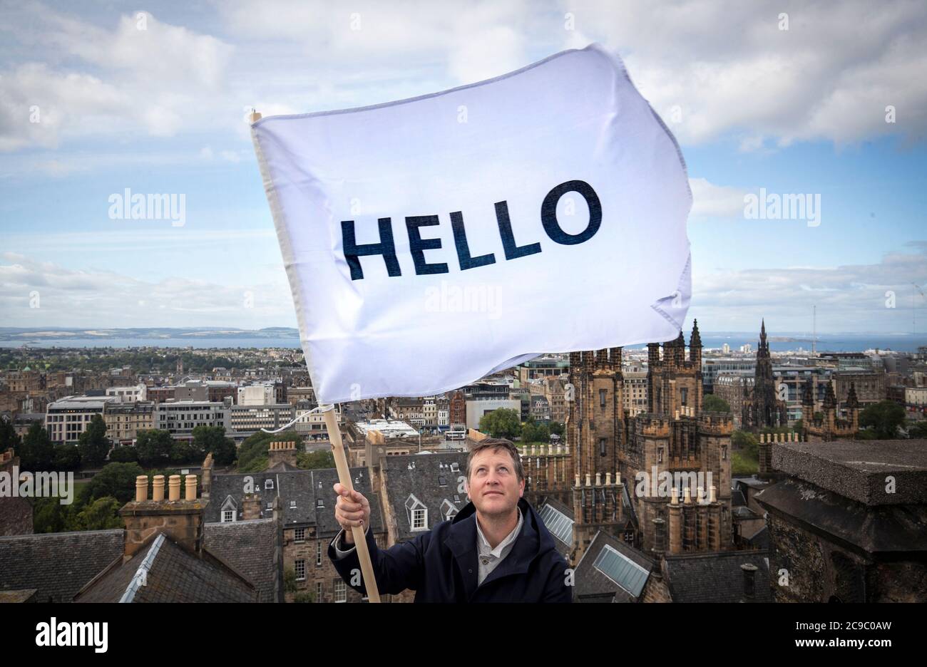 Der Künstler Peter Liversidge fliegt eine seiner HELLO-Flaggen über die Dächer Edinburghs, als er seine 2013 Edinburgh Art Festival commission Flags for Edinburgh wiederbesucht, die Gebäude in der ganzen Stadt dazu einlud, eine weiße Flagge zu fliegen, die HALLO. liest Stockfoto Der Künstler Peter Liversidge fliegt eine seiner HELLO-Flaggen über die Dächer Edinburghs, als er seine 2013 Edinburgh Art Festival commission Flags for Edinburgh wiederbesucht, die Gebäude in der ganzen Stadt dazu einlud, eine weiße Flagge zu fliegen, die HALLO. liest Stockfoto