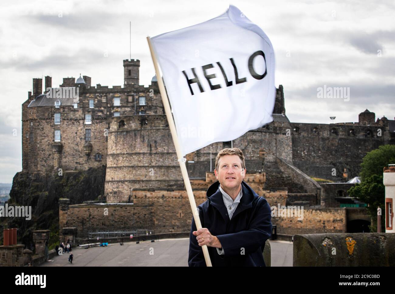 Der Künstler Peter Liversidge fliegt eine seiner HELLO-Flaggen über die Dächer Edinburghs, als er seine 2013 Edinburgh Art Festival commission Flags for Edinburgh wiederbesucht, die Gebäude in der ganzen Stadt dazu einlud, eine weiße Flagge zu fliegen, die HALLO. liest Stockfoto Der Künstler Peter Liversidge fliegt eine seiner HELLO-Flaggen über die Dächer Edinburghs, als er seine 2013 Edinburgh Art Festival commission Flags for Edinburgh wiederbesucht, die Gebäude in der ganzen Stadt dazu einlud, eine weiße Flagge zu fliegen, die HALLO. liest Stockfoto