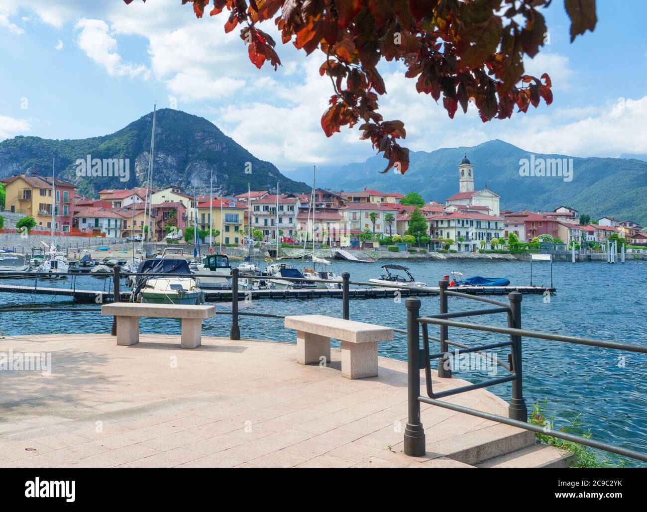 Schönes Panorama von einer Terrasse mit Blick auf den Lago Maggiore. Malerisches Dorf umgeben von Bergen mit einem Yachthafen.Italien Stockfoto
