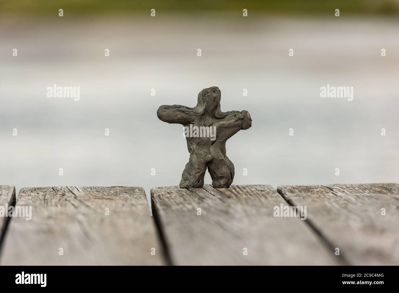 Kleine Lehmfigur aus Sand am Strand. Stockfoto