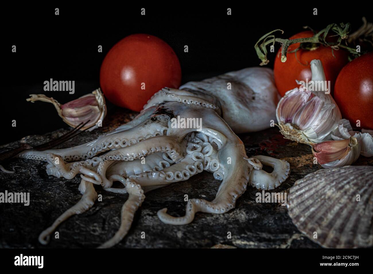 Frischer Oktopus mit Knoblauch und Tomaten Stockfoto