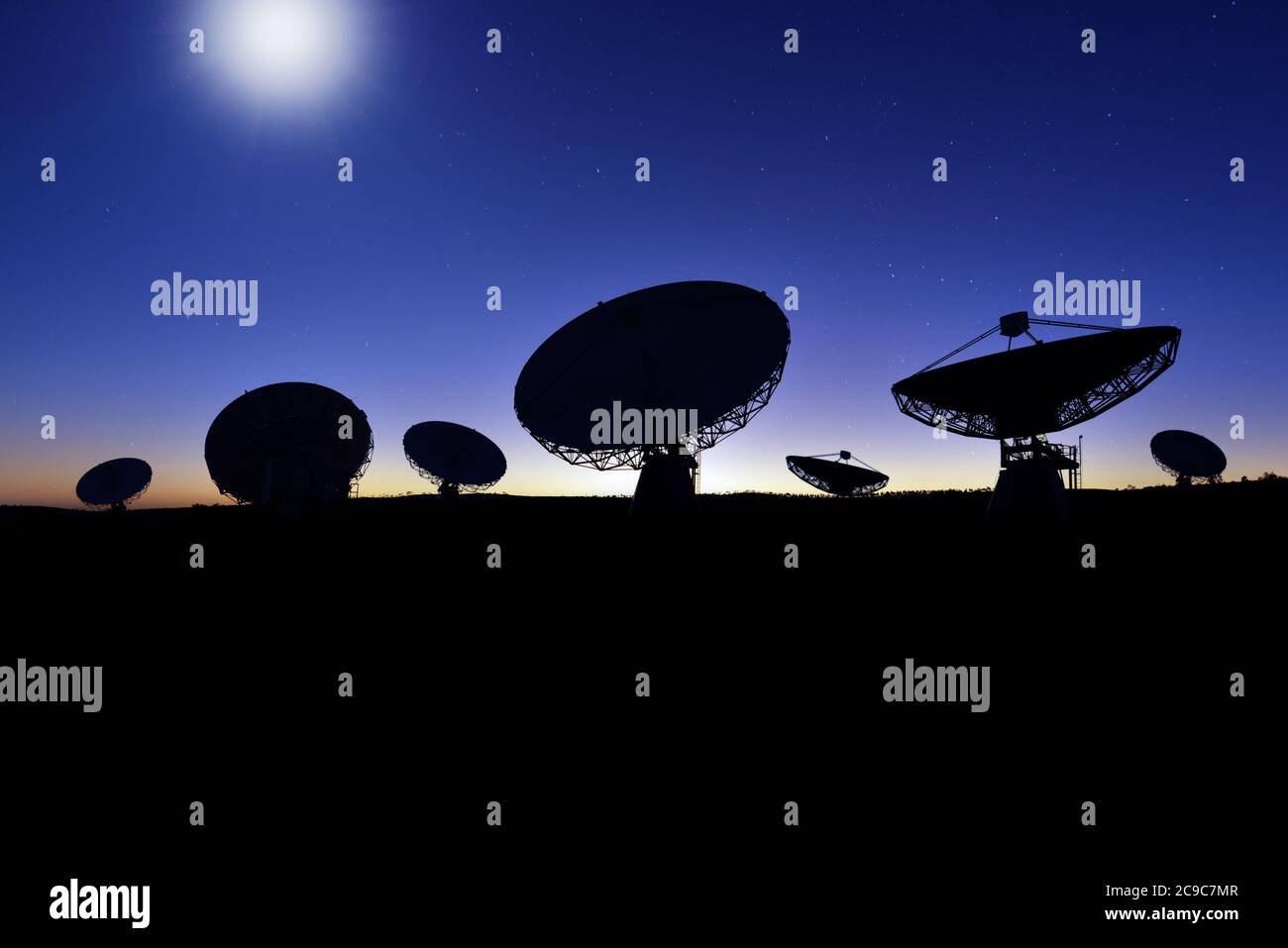 Mehrere Satelliten-Tracking-Gerichte in der Nacht durch Mondlicht beleuchtet. Stockfoto