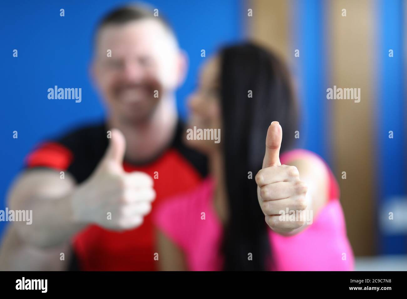Mann und Frau im Fitnessstudio zeigten eine gute Geste Stockfoto