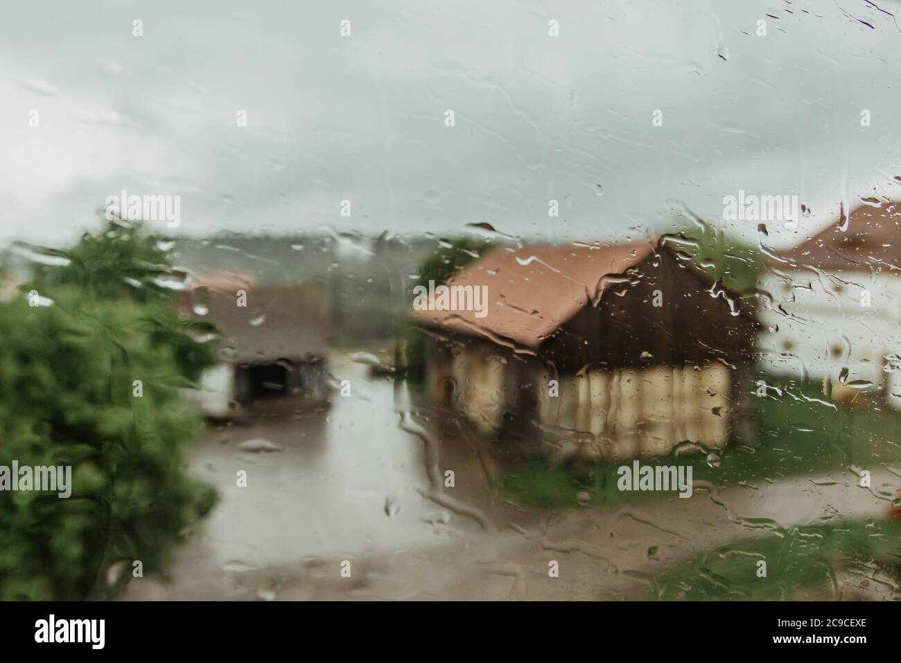 Tropfen auf Glas an regnerischen Tagen. Regen draußen am Herbsttag. Textur von Regentropfen, nasses Glas. Regenfenster Hintergrund.ländliche Landschaft. Sehen Sie durch Stockfoto