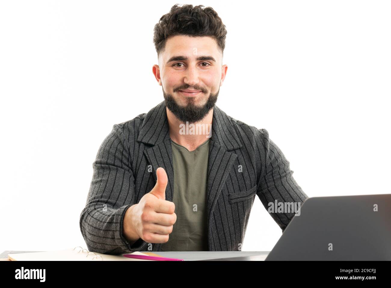 Bild eines hübschen jungen bärtigen Mannes, der über einer weißen Wand sitzt Hintergrund isoliert Stockfoto