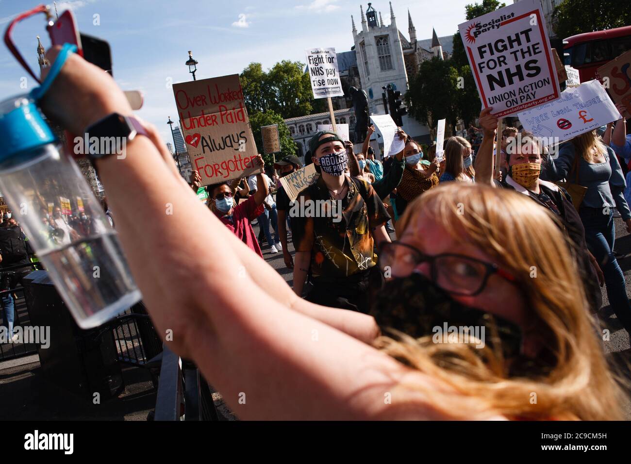 Mitarbeiter des National Health Service (NHS), die Masken tragen, sind mit Plakaten zu sehen, die gegen ihren Ausschluss von einer kürzlich angekündigten Lohnerhöhung im öffentlichen Sektor auf dem parliament Square protestieren.rund 900,000 Beschäftigte des öffentlichen Sektors in ganz Großbritannien werden in diesem Jahr als Dankesgeste des Finanzministeriums eine überhöhte Lohnerhöhung erhalten Während der Coronavirus-Pandemie. Die Gehaltserhöhung ist jedoch ausschließlich für Krankenschwestern und andere Mitarbeiter vor der Haustür aufgrund eines dreijährigen Lohnverhandlungs, den sie 2018 ausgehandelt haben, was sie dazu führte, aus Protest auf die Parliament Street in Richtung Downing Street in London zu marschieren. Stockfoto