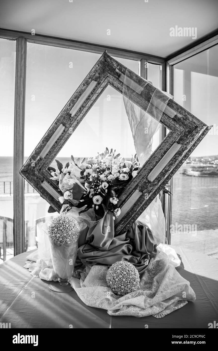 Blumenschmuck für die Hochzeit, in einem italienischen Restaurant, bestehend aus einem großen Holzrahmen. Der schöne Blick auf das Meer aus dem großen Fenster. Stockfoto