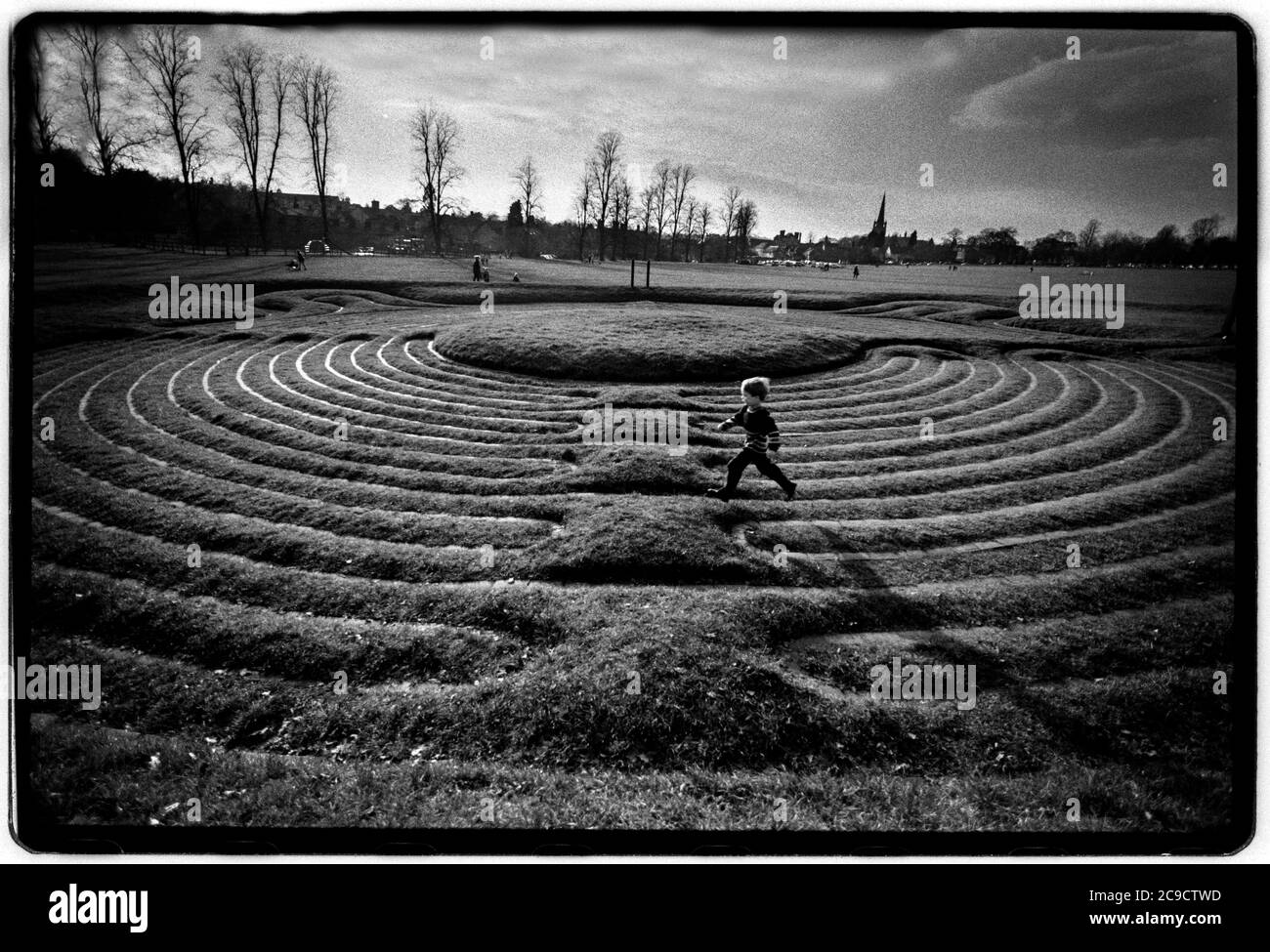 Saffron Walden Turf Maze auf Saffron Walden Common Essex England 1998 Jacob Harris, der Sohn des Fotografen, läuft um das Turf Maze auf dem Common. Das Turf Maze ist das größte in Großbritannien. Stockfoto