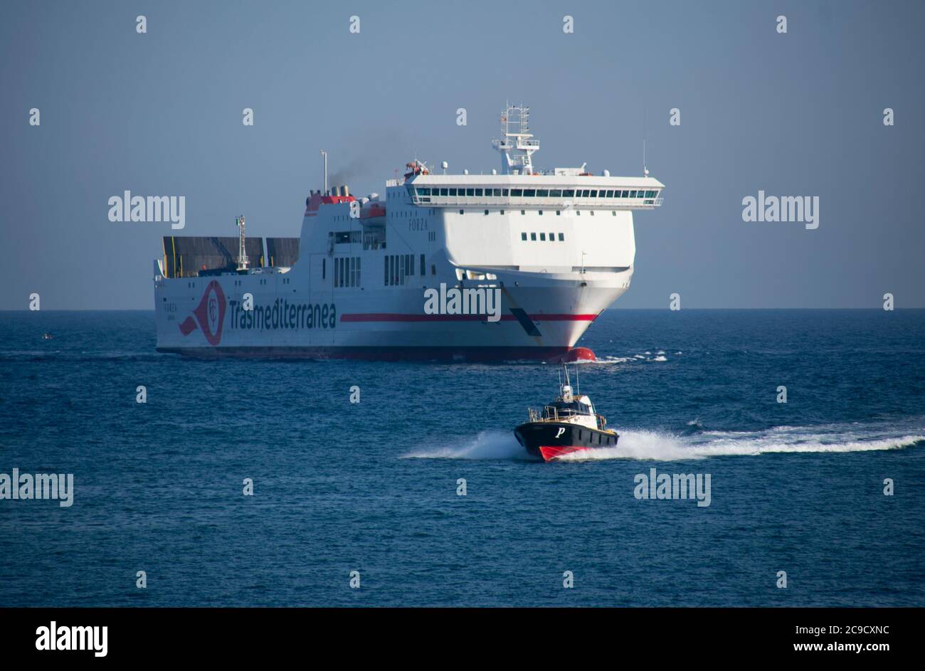 Forza Fähre Schiff der Firma Trasmediterránea in den Hafen von Barcelona vorausgegangen von der Piloten-Boot. Stockfoto