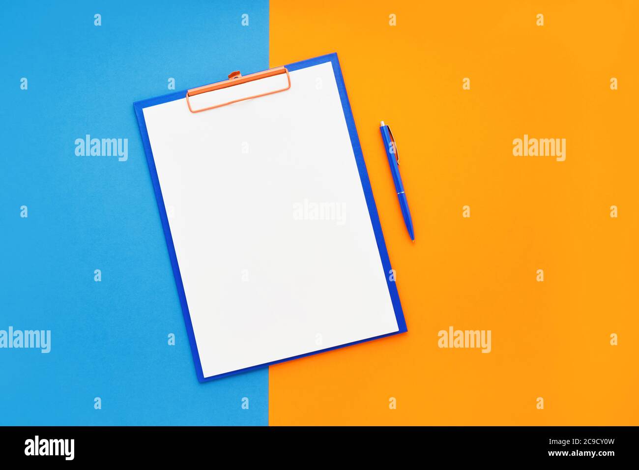 Leeres Clipboard-Modell und blauer Stift auf blau-orangefarbenem Hintergrund. Draufsicht, Kopierbereich für Text. Zurück zur Schule, Deadline, Morgenkonzept. Stockfoto