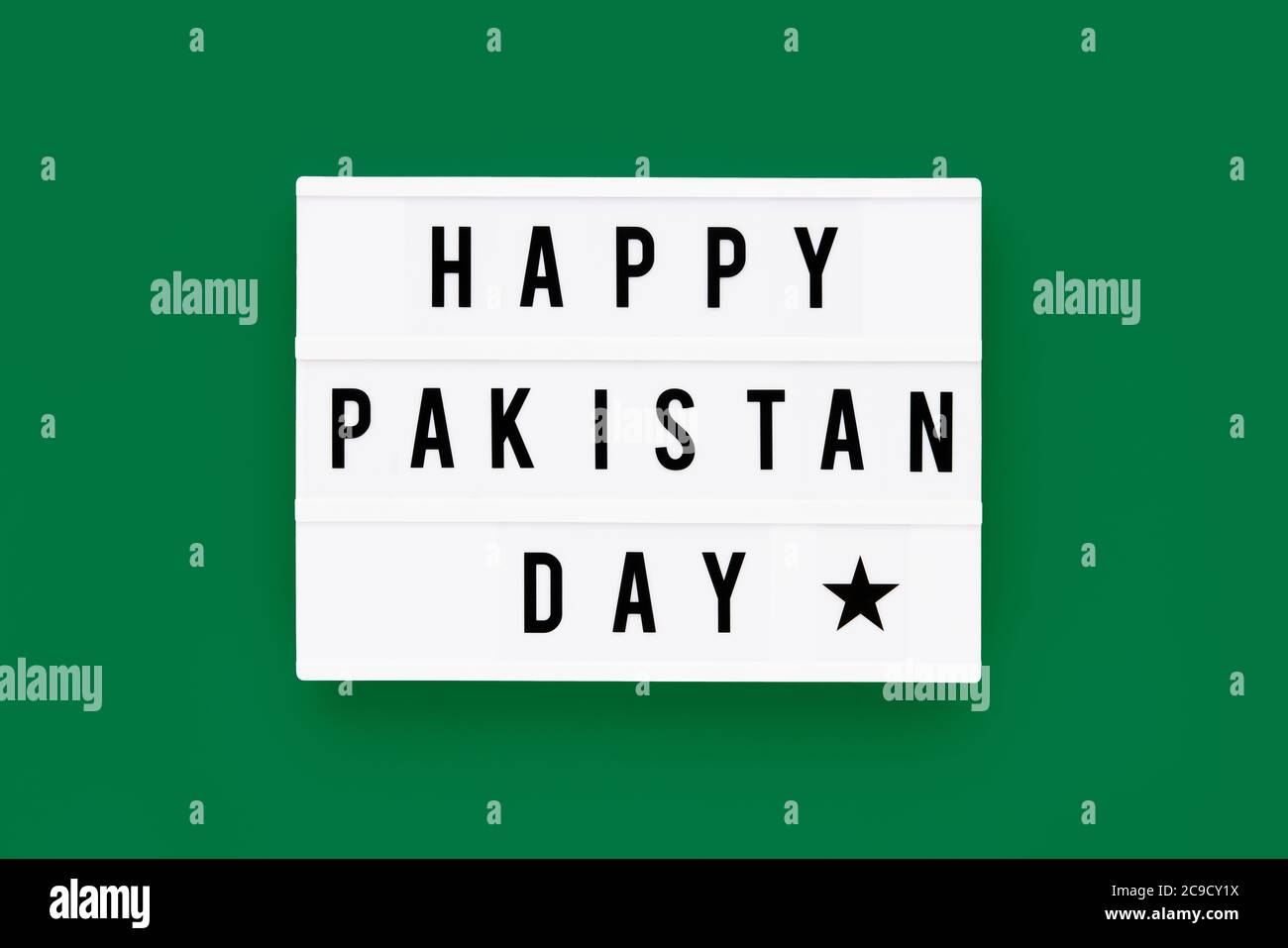 HAPPY PAKISTAN DAY in einem Leuchtkasten auf grünem Hintergrund geschrieben. Datum des Unabhängigkeitstages. Draufsicht. Stockfoto