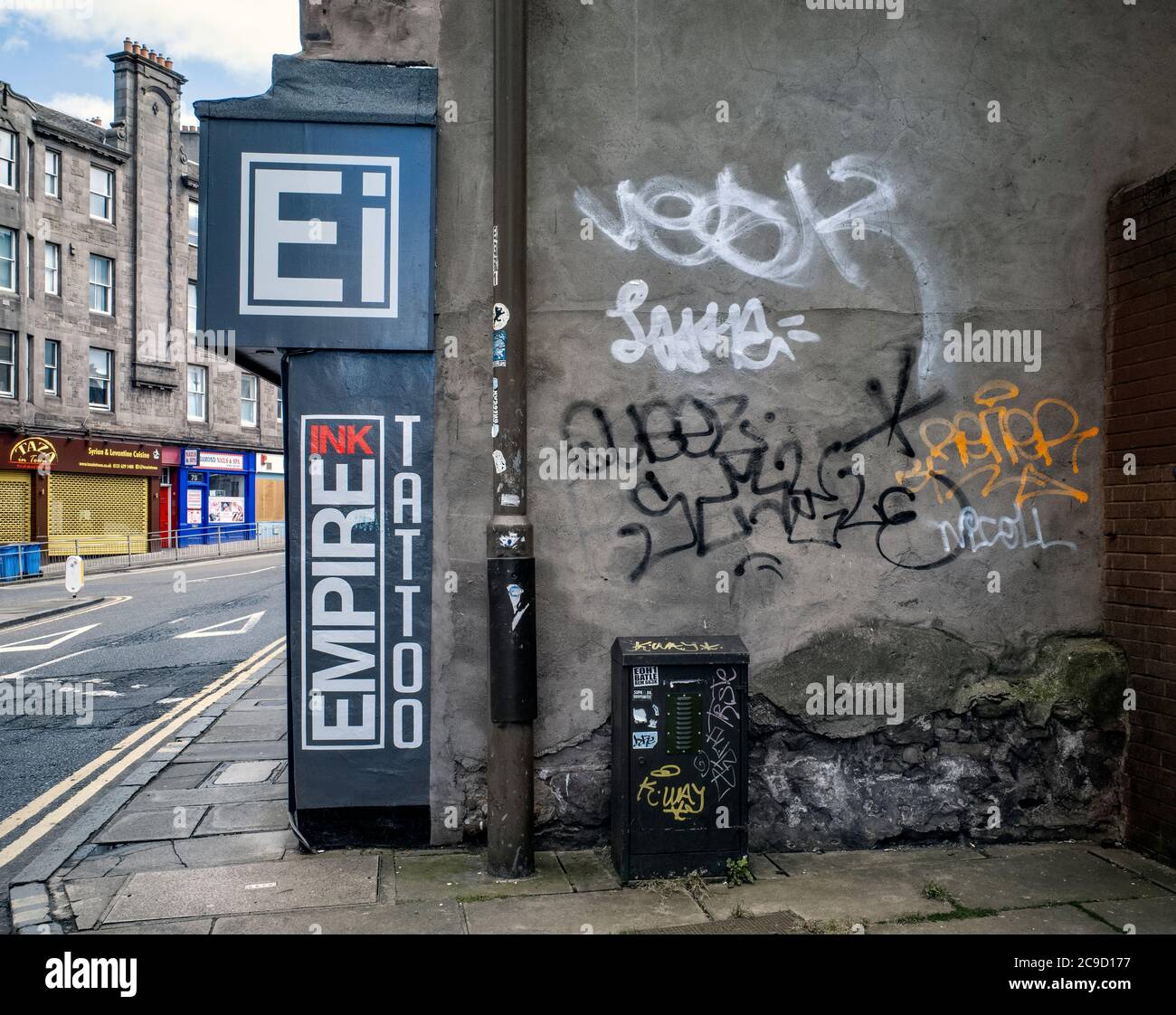 Graffiti und ein Schild für einen Tattoo-Künstler in Fountainbridge, Edinburgh, Schottland, Großbritannien. Stockfoto