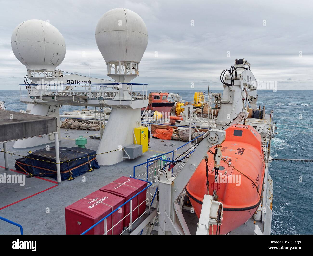 Das Oberdeck eines seismischen Schiffes auf Operationen in der Nordsee, mit seiner festgebundenen Ausrüstung und 2 großen Satellitenantenne Stockfoto