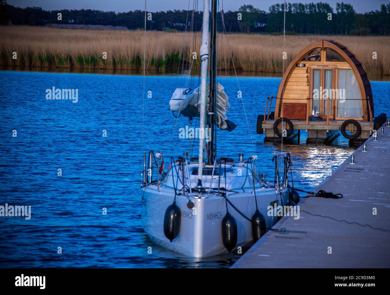 Gager, Deutschland. Mai 2020. Ein Segelboot und ein Wohnfloß werden nach Sonnenuntergang im kleinen Hafen festgemacht. Quelle: Jens Büttner/dpa-Zentralbild/ZB/dpa/Alamy Live News Stockfoto