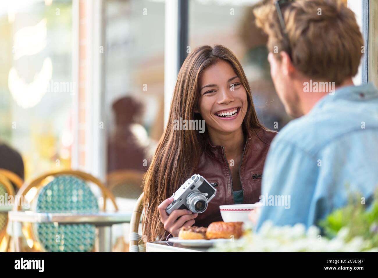 Ein Paar im Cafe Lifestyle. Junge Touristen frühstücken am Restauranttisch auf der Außenterrasse des pariser Bistros in der europäischen Stadt. Asiatisch Stockfoto