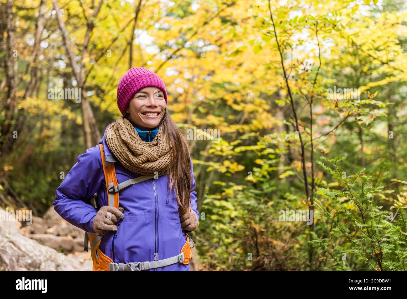 Glückliche asiatische Frau Wandern im Herbst Wald Natur Wandern auf Wanderweg. Hiker Mädchen mit Rucksack, Hut, Schal und Jacke auf Herbst Abenteuer reisen Stockfoto