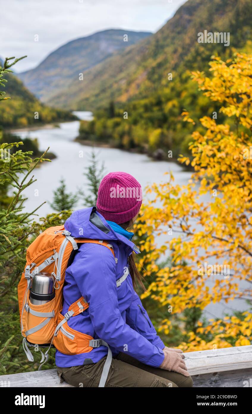 Frau Wanderer Wandern Blick auf die malerische Aussicht auf Herbst Laub Berglandschaft. Abenteuer Reise im Freien Person stehend entspannend in der Nähe des Flusses während Stockfoto