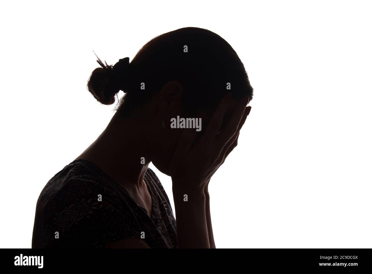 Silhouette eines jungen Mädchens mit Problemen, Seitenansicht mit Händen auf dem Kopf - isoliert, noname Stockfoto