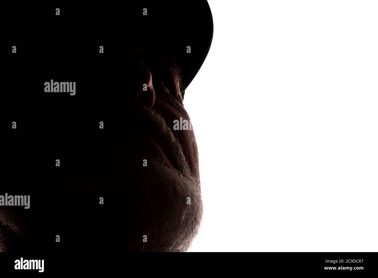 Porträt eines alten Mannes, in einer Spitzenmütze, mit Bart, Seitenansicht - dunkel isoliert Silhouette Stockfoto